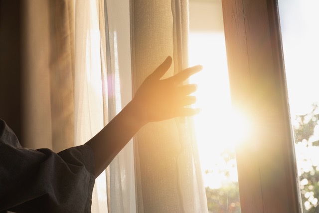 Person looking at sunshine through window